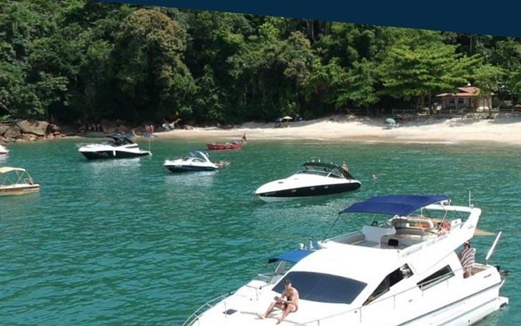 Intermarine 44 ancorada em enseada de água verde, outras lanchas ao fundo